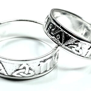 Könnte beinhalten: Zwei silberne Ringe mit keltischen Knotendesigns und der Inschrift "Aisling" auf jeder Band.