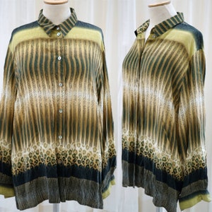 Puede incluir: Camisa abotonada estampada con rayas verticales en tonos beige y verde, y un diseño de estampado de leopardo en la parte inferior. El cuello y los puños tienen un ribete verde liso. La camisa se exhibe en un maniquí.