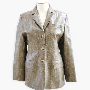May include: A brown blazer with a herringbone pattern and gold buttons. The blazer has a single breasted closure and two pockets.
