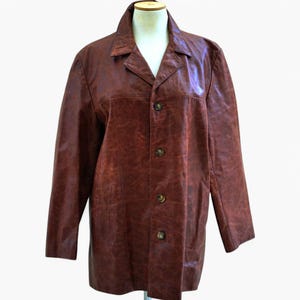Peut inclure: Une veste en cuir marron avec un devant boutonné et des manches longues.