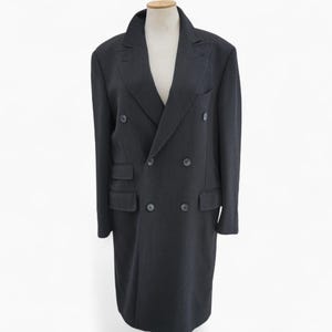 May include: A dark gray double-breasted overcoat with a notched lapel and two rows of buttons. The coat has two front pockets and a tailored fit, displayed on a mannequin.