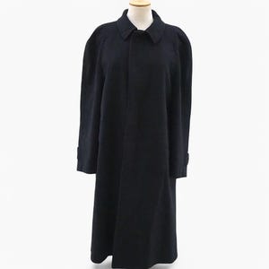 Pode incluir: Um casaco comprido de lã azul escuro com colarinho clássico e fecho de um só botão.