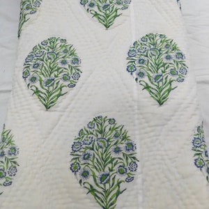 May include: White cotton quilt with a repeating pattern of blue and green floral designs. The quilt is quilted in a diamond pattern.