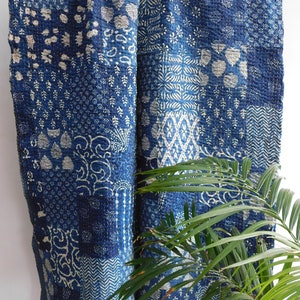 May include: A blue and white kantha quilt with a patchwork design. The quilt is made of cotton and is hand-stitched. It features a variety of floral and geometric patterns.