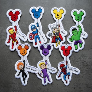 Puede incluir: Parches bordados con superh&eacute;roes de Marvel, cada uno sosteniendo un globo con forma de Mickey Mouse con un n&uacute;mero. Los personajes incluyen a Iron Man, Capit&aacute;n Am&eacute;rica, Thor, Hulk, Viuda Negra, Ojo de Halc&oacute;n y Spider-Man. Bordes blancos.