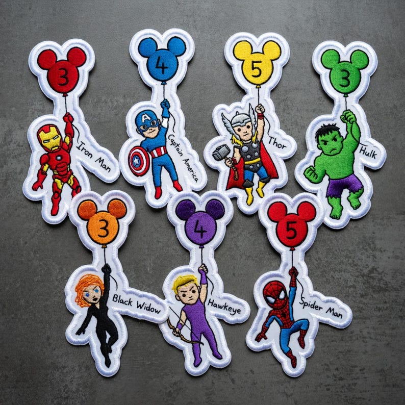 Puede incluir: Parches bordados con superh&eacute;roes de Marvel, cada uno sosteniendo un globo con forma de Mickey Mouse con un n&uacute;mero. Los personajes incluyen a Iron Man, Capit&aacute;n Am&eacute;rica, Thor, Hulk, Viuda Negra, Ojo de Halc&oacute;n y Spider-Man. Bordes blancos.
