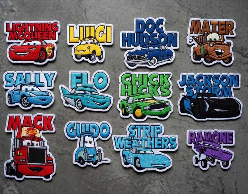 May include: A selection of embroidered patches showcasing characters from the film "Cars." Each patch features a car character's name in a vibrant font, alongside the car's image. Characters include Lightning McQueen, Mater, and Doc Hudson.