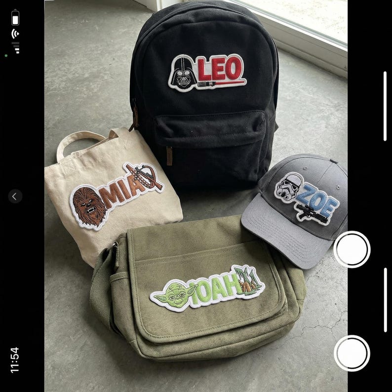 Puede incluir: Una mochila negra, un bolso de mano beige, un bolso bandolera verde oliva y una gorra de b&eacute;isbol gris. Cada art&iacute;culo presenta un parche tem&aacute;tico de Star Wars con un nombre. La mochila tiene un parche de Darth Vader con el nombre "LEO".