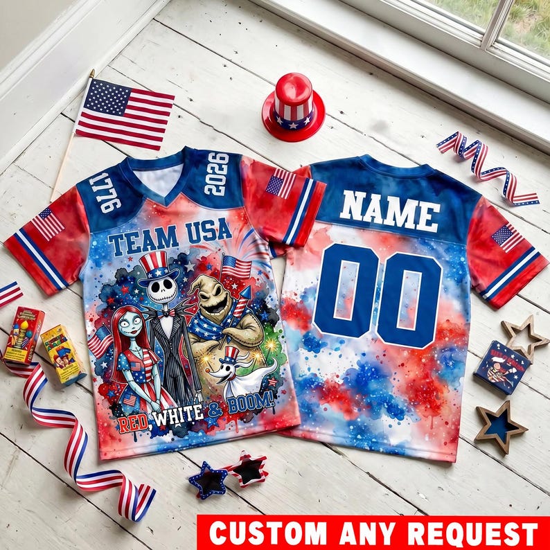 May include: Two patriotic jerseys featuring a red, white, and blue watercolor design. The front displays characters from The Nightmare Before Christmas, the text 'TEAM USA', '1776', '2026', and 'RED WHITE & BOOM!'. The back features 'NAME' and '00'.