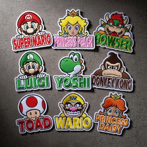 May include: A white ceramic mug with a black handle and the text "But First, Coffee" in a bold, black font. The mug is set against a blurred background, suggesting a cozy setting. The mug appears to be approximately 4 inches tall.