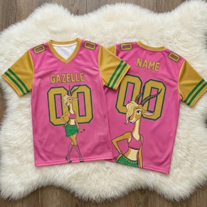 May include: Pink jersey with yellow sleeves and green stripes. The jersey features the name "GAZELLE" and the number "00" in gold. A cartoon gazelle is on the front. The back of the jersey has the word "NAME" and the number "00".