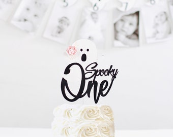 Decoração assustadora de topo de bolo de aniversário. A decoração assustadora de um aniversário. Primeiro aniversário de Halloween, decoração de festa fantasma rosa.