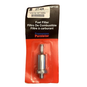 May include: A silver fuel filter with a red and white packaging. The packaging has the text "377-424", "FILTER, FUEL, FACET, 74 MICRON", "FEP735", "Fuel Filter", "Filtro De Combustible", "Filtre à carburant", and "Purolator".
