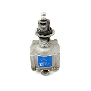 May include: A metallic selector switch featuring a cylindrical threaded top section with a small metal tip and a square-shaped base. A blue rectangular label is attached to the side with the text S-232-1 SELECTOR SWITCH JOHNSON SERVICE CO. MILWAUKEE, WIS. MADE IN U.S.A.