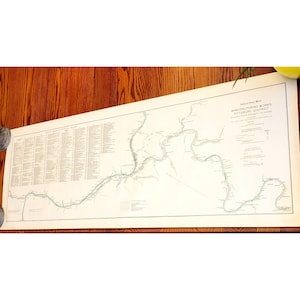 May include: An industrial map of the Pittsburgh District, showing the proximity to rivers. The map is printed on a long, rectangular sheet of paper. The map is in black and white, with a detailed depiction of the river and surrounding areas. The map is rolled up on both ends.