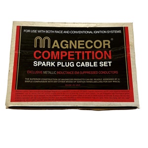May include: A brown cardboard box with a red and black label that reads "Magnecor Competition Spark Plug Cable Set". The label also states "Exclusive Metallic Inductance EMI Suppressed Conductors" and "Made in USA".