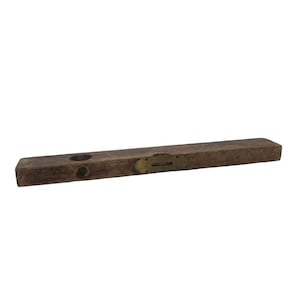 May include: A vintage wooden spirit level tool featuring a rectangular body with a weathered brown finish. The tool includes a central brass-encased horizontal vial and two circular openings on one end, showcasing a worn, aged texture throughout.