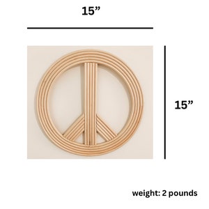 K&ouml;nnte beinhalten: Ein 38 cm gro&szlig;es, rundes Wanddekor in Form eines Friedenszeichens aus geflochtenem Rattan. Das Friedenszeichen ist hellbraun und hat eine nat&uuml;rliche Oberfl&auml;che. Es wiegt 0,9 kg.