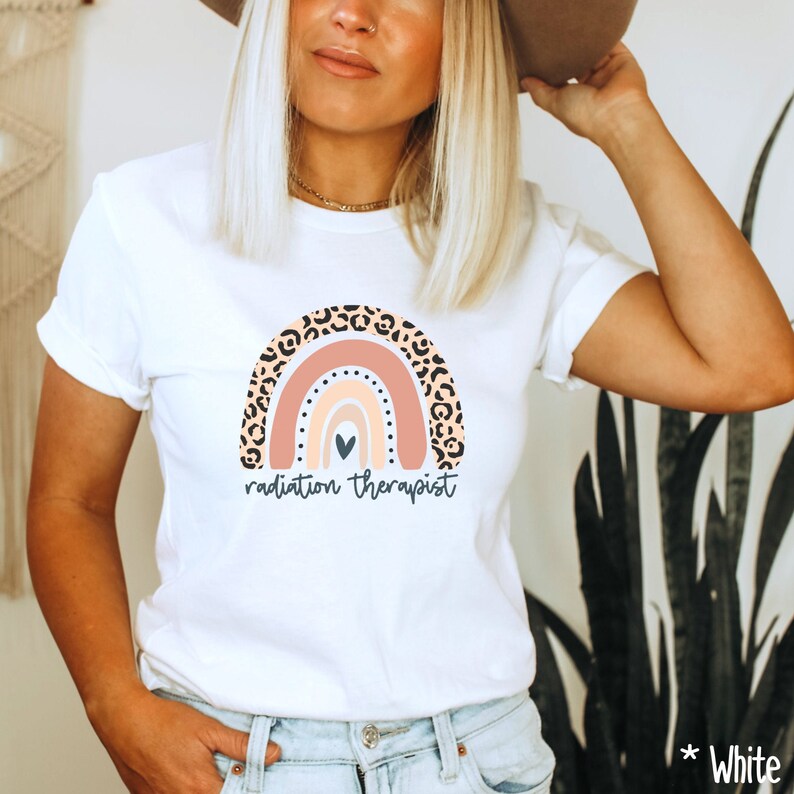 Puede incluir: Camiseta blanca con un dise&ntilde;o de arco&iacute;ris con estampado de leopardo y el texto "radiation therapist".