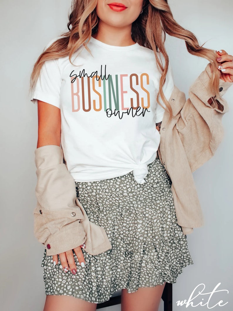 Puede incluir: Una camiseta blanca con el texto "small business owner" en rayas verticales de colores. El texto est&aacute; en un estilo de fuente moderno.