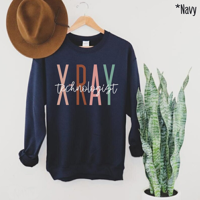 May include: Navy blue sweatshirt with the text "XRAY technologist" in colourful letters. The letters are in shades of pink, orange, brown, and green.