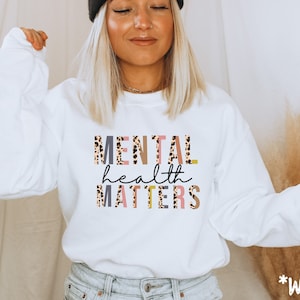 May include: White sweatshirt with the text "MENTAL health MATTERS" in pink, gray, and yellow letters with a leopard print pattern.