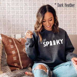 May include: A dark heather grey sweatshirt with the text "Let's get spooky" and three ghost illustrations in white.