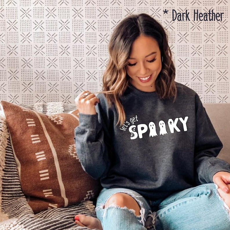 May include: A dark heather grey sweatshirt with the text "Let's get spooky" and three ghost illustrations in white.