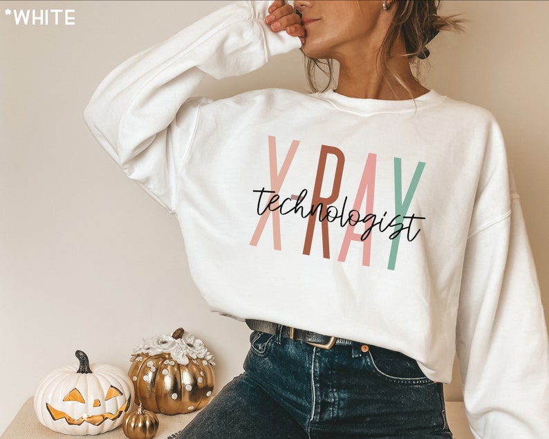 May include: White sweatshirt with the text "XRAY technologist" in colourful letters. The letters are in shades of pink, brown, and green.