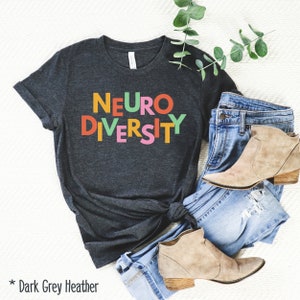May include: Dark grey heather t-shirt with the text "NEURODIVERSITY" in colorful block letters.