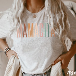 May include: A gray t-shirt with the word "MAMACITA" printed in rainbow colors.