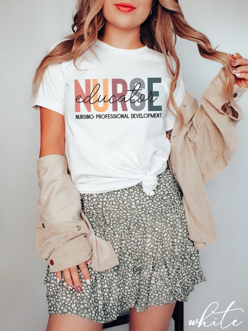 May include: White t-shirt with the text "NURSE educator NURSING PROFESSIONAL DEVELOPMENT" in colorful letters.