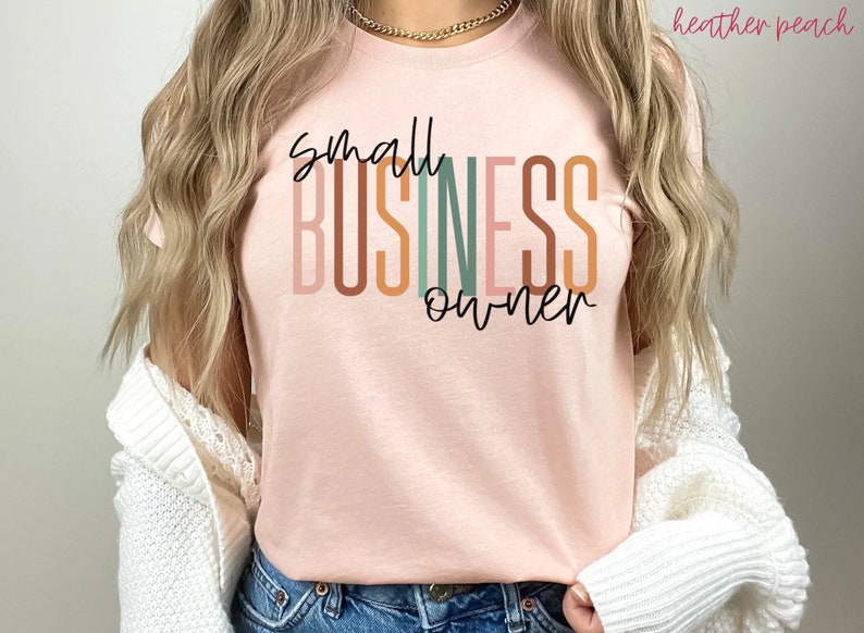 Puede incluir: Una camiseta rosa con el texto "small business owner" en rayas verticales de colores. El texto est&aacute; en una fuente moderna y manuscrita.
