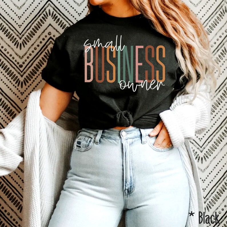 Puede incluir: Una camiseta negra con el texto "small BUSINESS owner" en letras de colores. Las letras est&aacute;n apiladas verticalmente y el texto est&aacute; centrado en la camiseta.