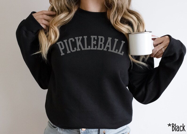 May include: Black sweatshirt with the text "PICKLEBALL" in a grey arch design.