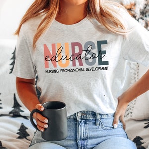 May include: A gray t-shirt with the text "NURSE educator" in colorful letters. The text "NURSING PROFESSIONAL DEVELOPMENT" is printed below the main text.