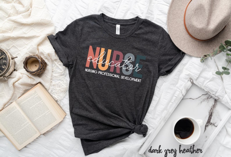 May include: Dark grey heather t-shirt with the text "NURSE educator" in colorful letters and the words "NURSING PROFESSIONAL DEVELOPMENT" in white below.