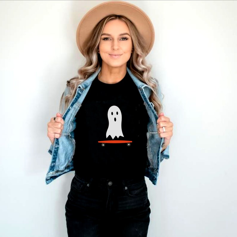 Peut inclure: T-shirt noir avec un motif de fant&ocirc;me blanc sur un skateboard orange. Le fant&ocirc;me a un design simple. Ce t-shirt d&eacute;contract&eacute; est id&eacute;al pour un usage quotidien, notamment pour Halloween ou la saison effrayante.