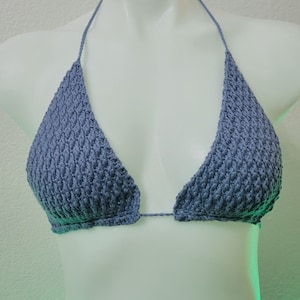 May include: A blue crocheted bikini top with a triangle shape.
