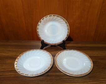 May include: Three white milk glass bowls with a gold rim. The bowls have a swirl design and are perfect for serving desserts or snacks.