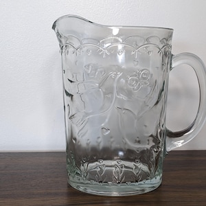 May include: A set of three ceramic mugs with a speckled, matte finish. The mugs are in shades of cream, light gray, and dark gray. Each mug has a simple, minimalist design and a rounded handle. The mugs are stacked on top of each other.