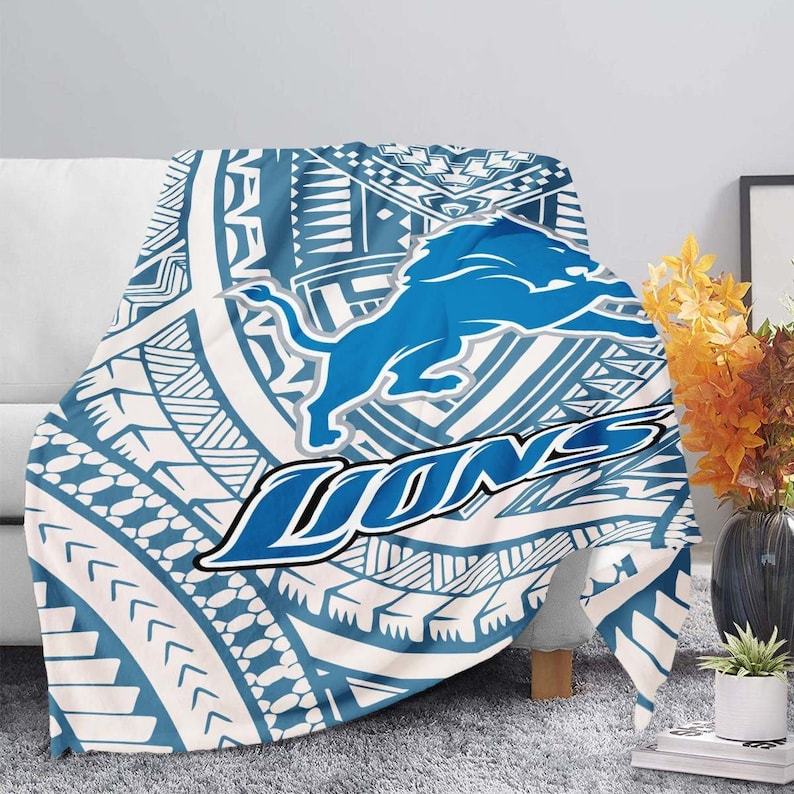May include: A blue and white throw blanket with a tribal pattern and a blue lion logo with the word "LIONS" in a blue arc.