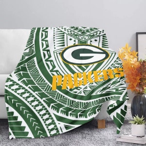 May include: Green and white throw blanket with a green and yellow Green Bay Packers logo and the word "Packers" in yellow. The blanket has a tribal pattern.