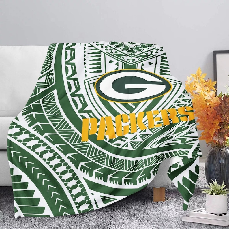 May include: Green and white throw blanket with a green and yellow Green Bay Packers logo and the word "Packers" in yellow. The blanket has a tribal pattern.