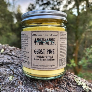 May include: A glass jar with a silver lid filled with yellow pine pollen. The label reads "American River Pine Pollen", "Ghost Pine", "Wildcrafted Raw Pine Pollen", and "Dietary Supplement / 60 grams".