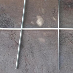 May include: A white grid pattern on a grey textured surface.