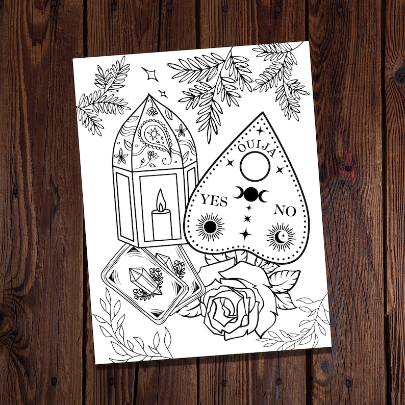 May include: A black and white line art illustration of a Ouija board, a lantern, tarot cards, and a rose. The Ouija board has the words "OUIJA", "YES", "NO", and a crescent moon and sun symbol. The lantern has a paisley design. The tarot cards have a crystal design. The rose has a stem and leaves.