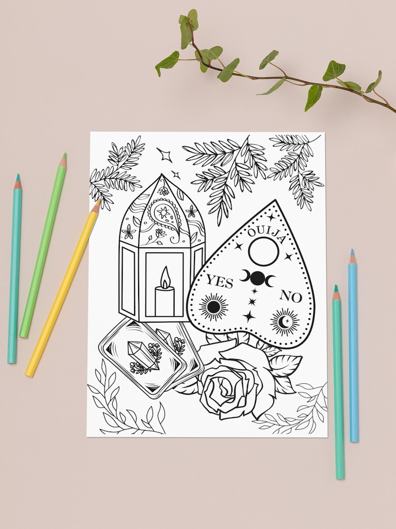 May include: A black and white line drawing of a Ouija board, a lantern, tarot cards, and a rose. The Ouija board has the words "YES", "NO", and "OUIJA" on it. The lantern has a candle inside. The tarot cards have a crystal on top of them. The rose has a stem and leaves.