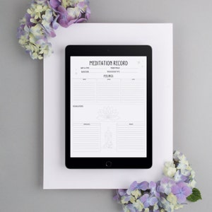 K&ouml;nnte beinhalten: Ein digitales Tablet zeigt ein druckbares Meditations-Tagebuch mit Abschnitten f&uuml;r Datum, Uhrzeit, Dauer, Mondphase, Meditationsart, Gef&uuml;hle, Visualisierungen, Eindr&uuml;cke und Erkenntnisse. Das Blatt ist mit Sternen und einer Lotusblume verziert.