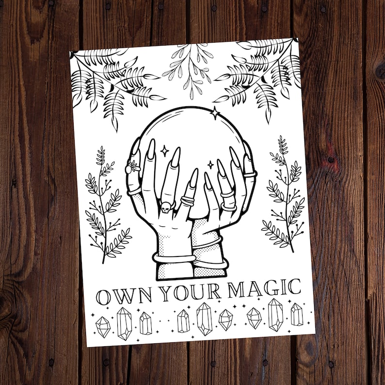 May include: Black and white illustration of hands holding a crystal ball, with long nails and rings. The image includes the text "OWN YOUR MAGIC" and decorative crystals and foliage. The artwork is on a white background.